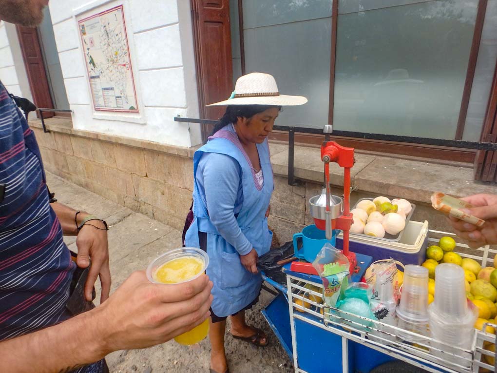 Buying a fresh orange juice from a street seller in Sucre, Bolivia