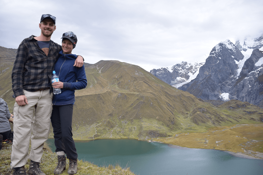 a couple standing in front of a lake in peru