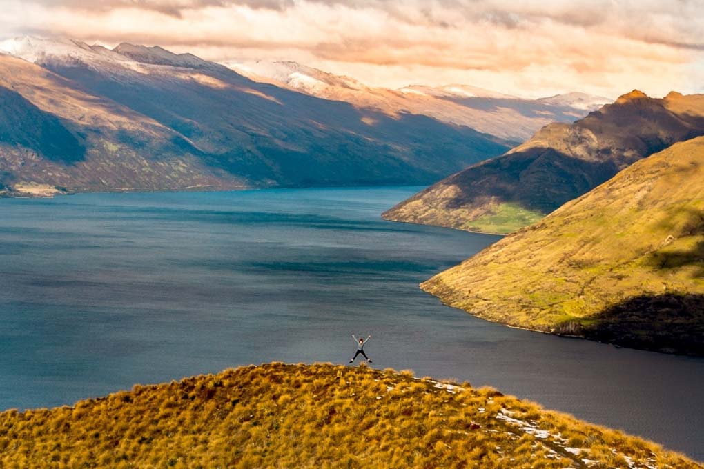 A woman standing on the Ben lomond Track over Lake Wakatipu