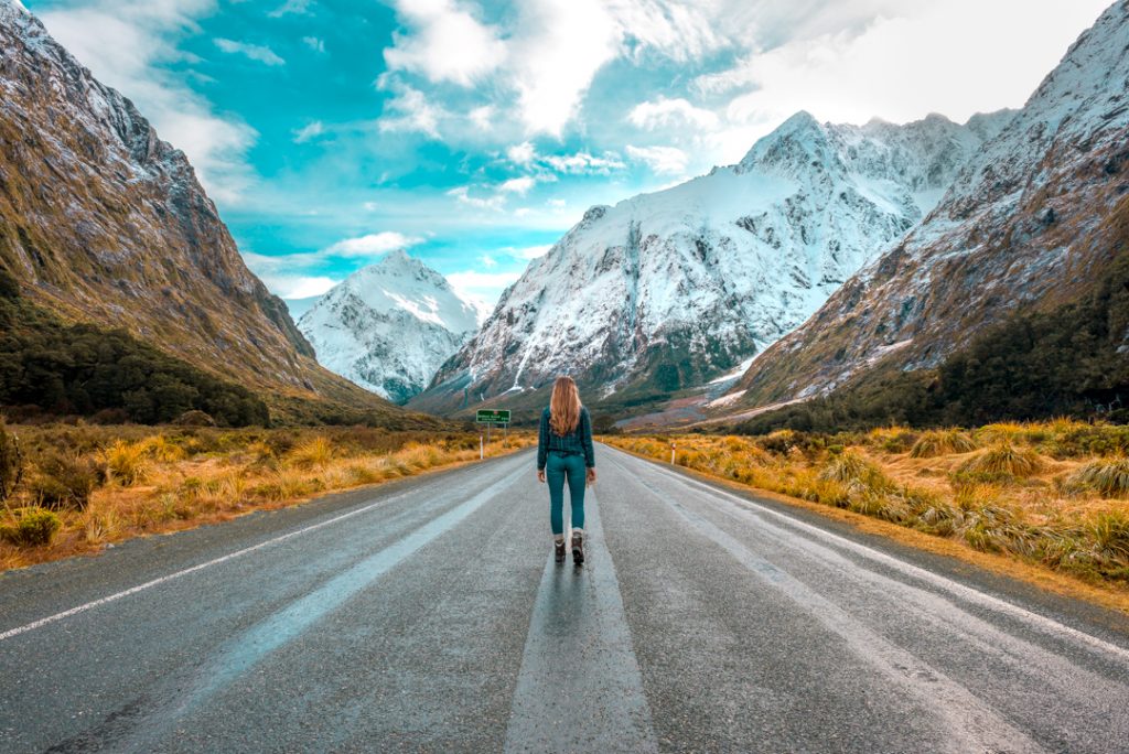 Bailey standing on a stretch of road between Te Anau and Milford Sound