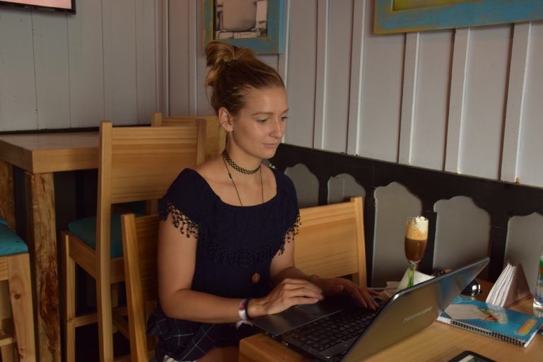 woman sitting at a desk in a cafe working on the computer