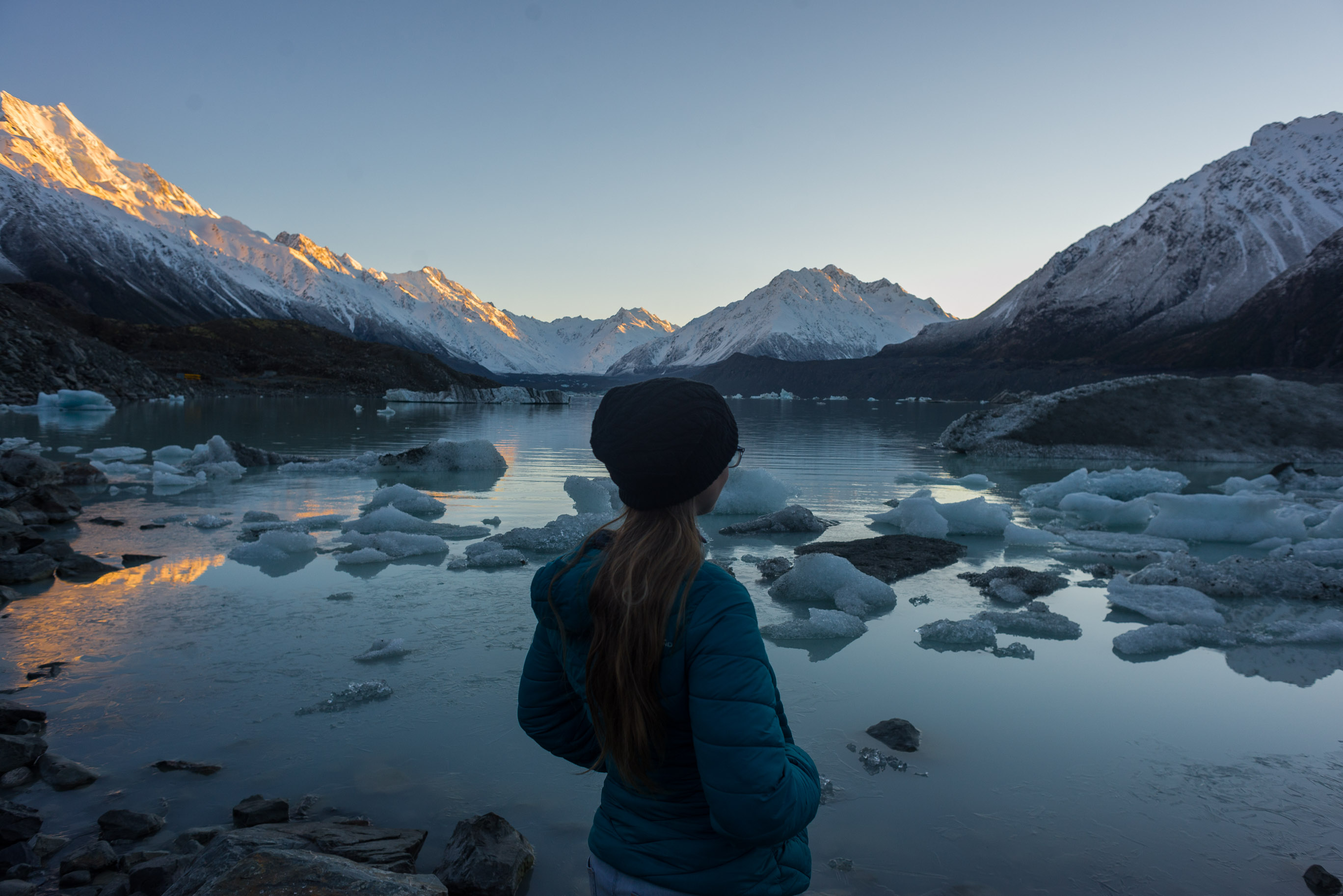 Bailey standing looking over the Tasman Lake at sunrise