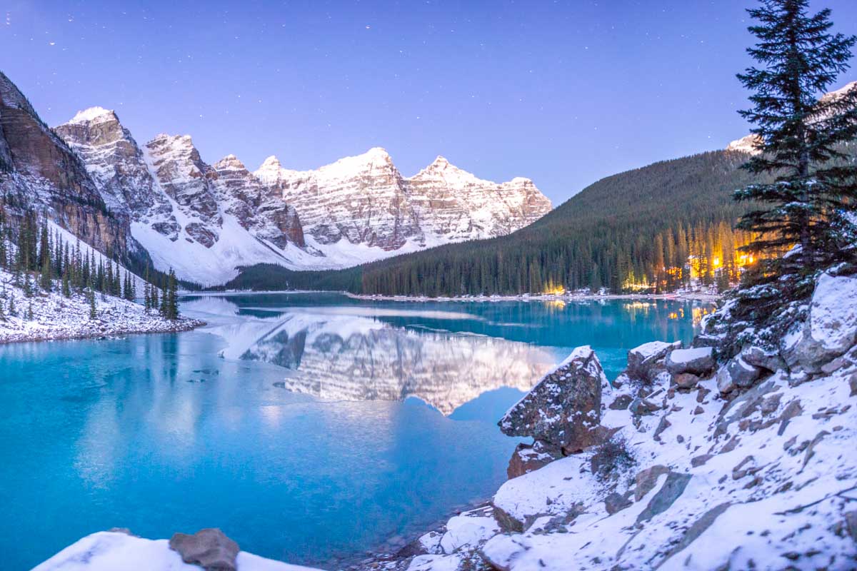 Moraine Lake with lights from the Lake Louise hotel area at sunrise in Banff