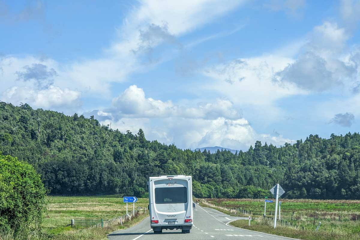 A motorhome drives along a remote road in New Zealand