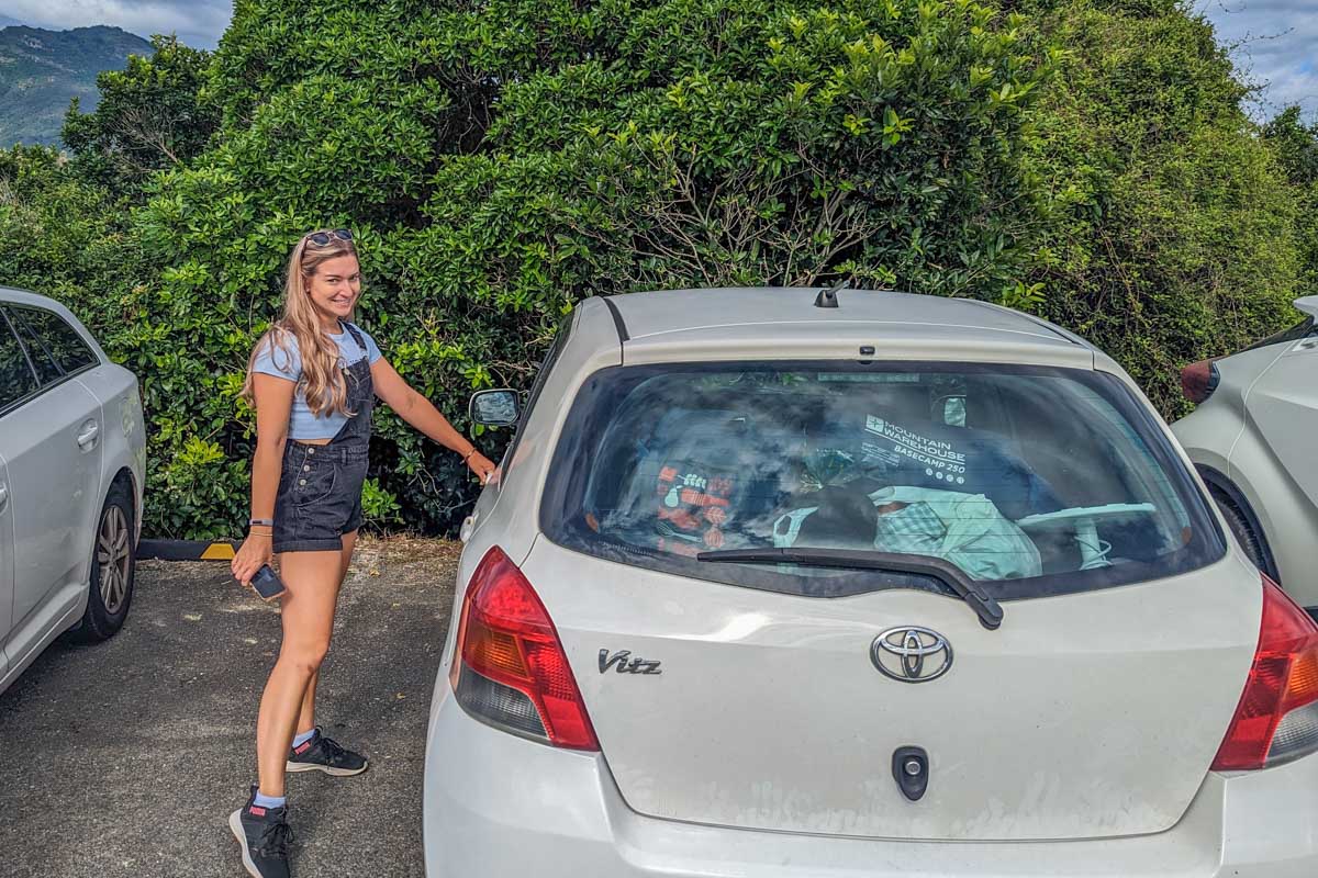 Bailey poses with her rental car in New Zelaand