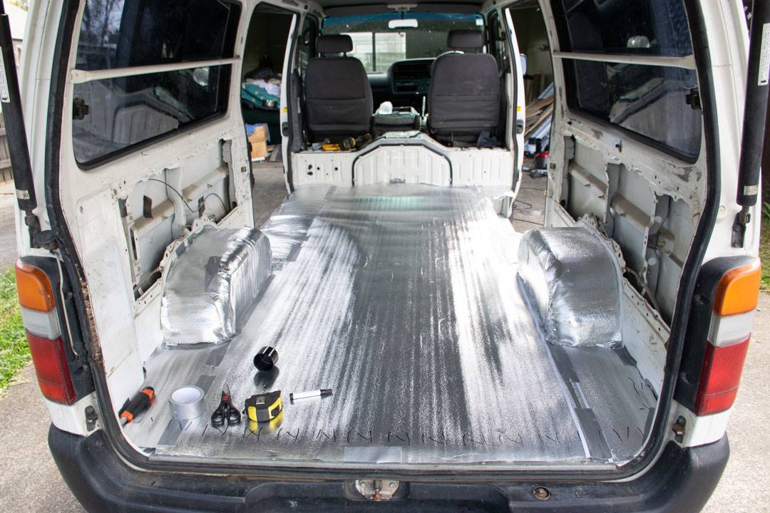 Laying down vapor barrier during a campervan conversion