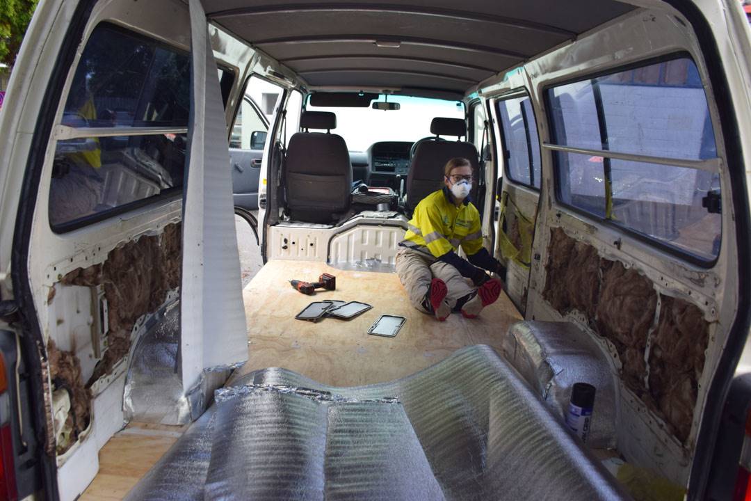 Stuffing the voids with insulation during our campervan conversion
