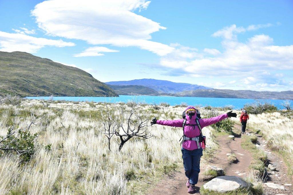 woman poses in Torres del Paine national park all bunled up