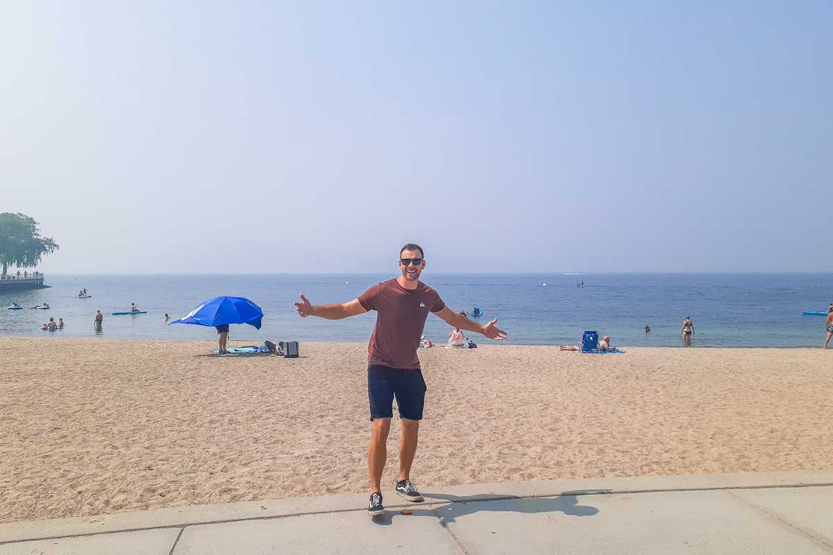A man poses for a photo at a beach in Kelowna called Tugboat Beach