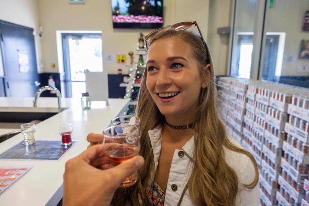 Bailey laughs while drinking cider at a cider brewery in Kelowna, Canada