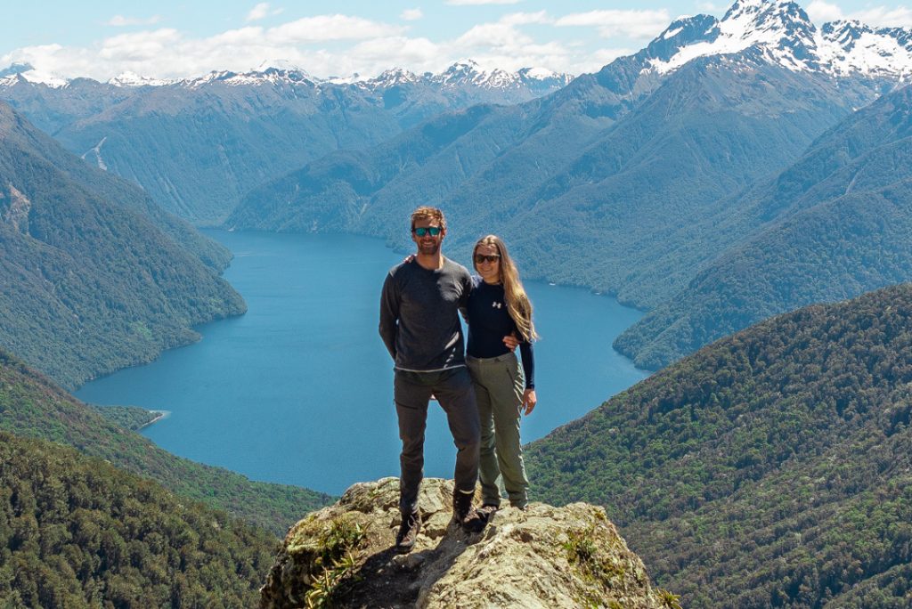 Bailey and Daniel from New Zealand Trip Planner stand on a viewpoint from the Kepler Track in New Zealand