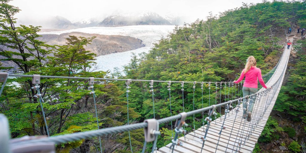 Bailey walks accross a suspension bridge in Torres del Paine National Park, Patagonia