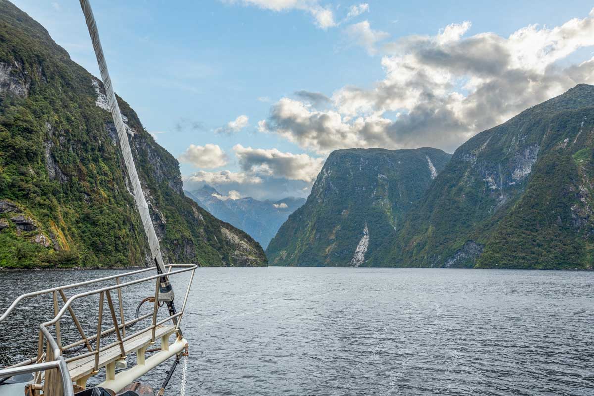 A boat cruises through Doubtful Sound in New Zealand