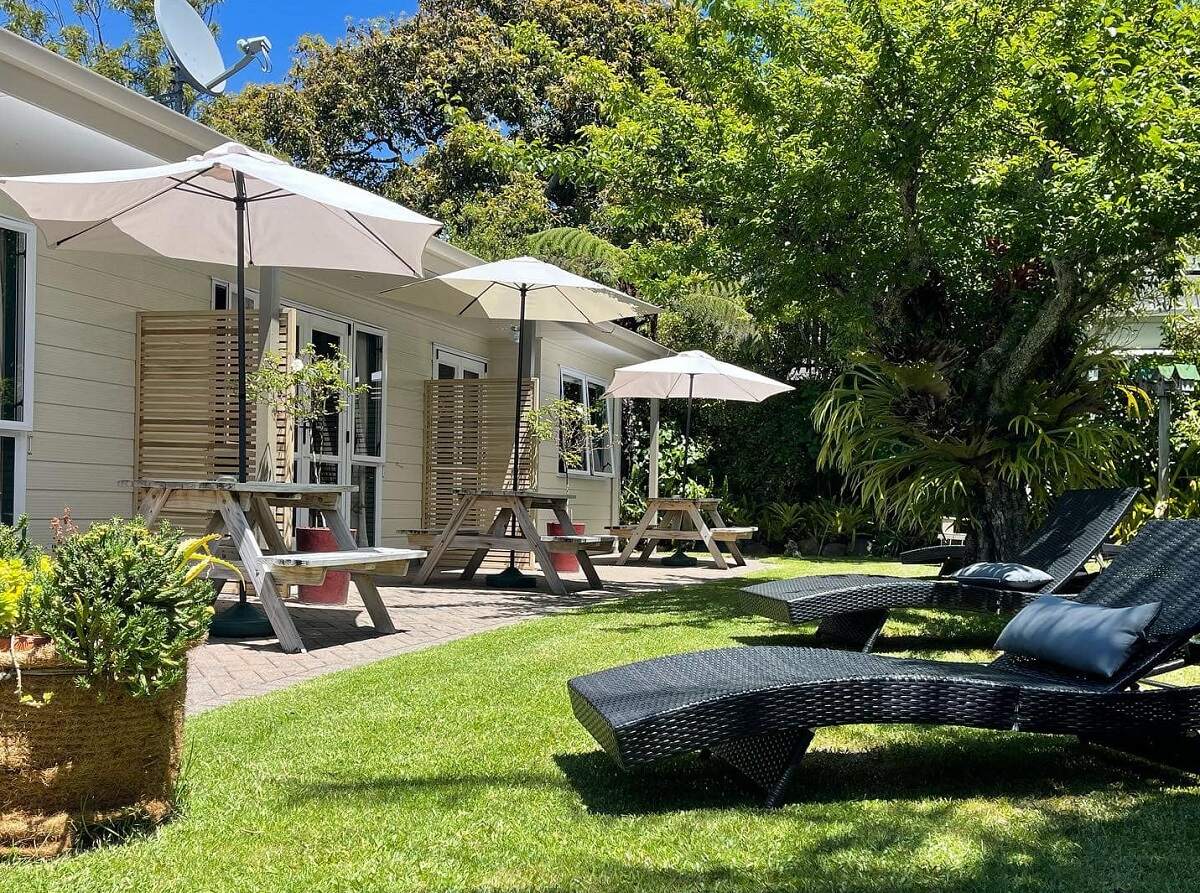 the courtyard at Tatahi Lodge, green grass with lounge chairs outside of the room patios