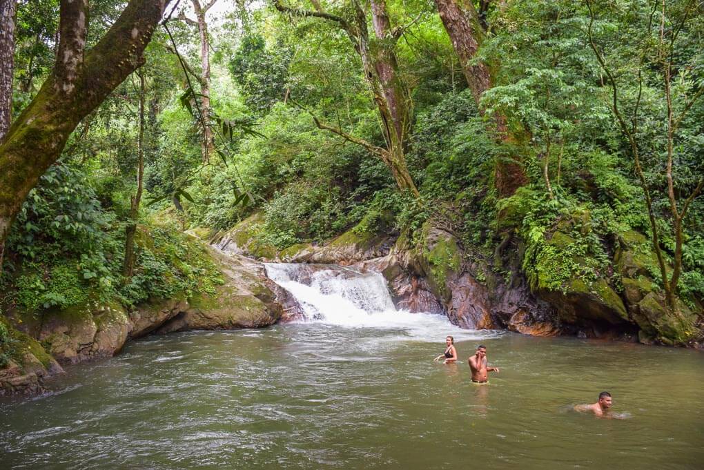 People swim at Pozo Azul in Minca, Colombia