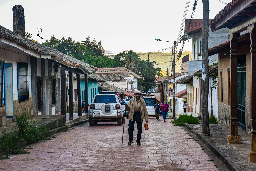 An old man walks down a street in Samaipata, Bolivia