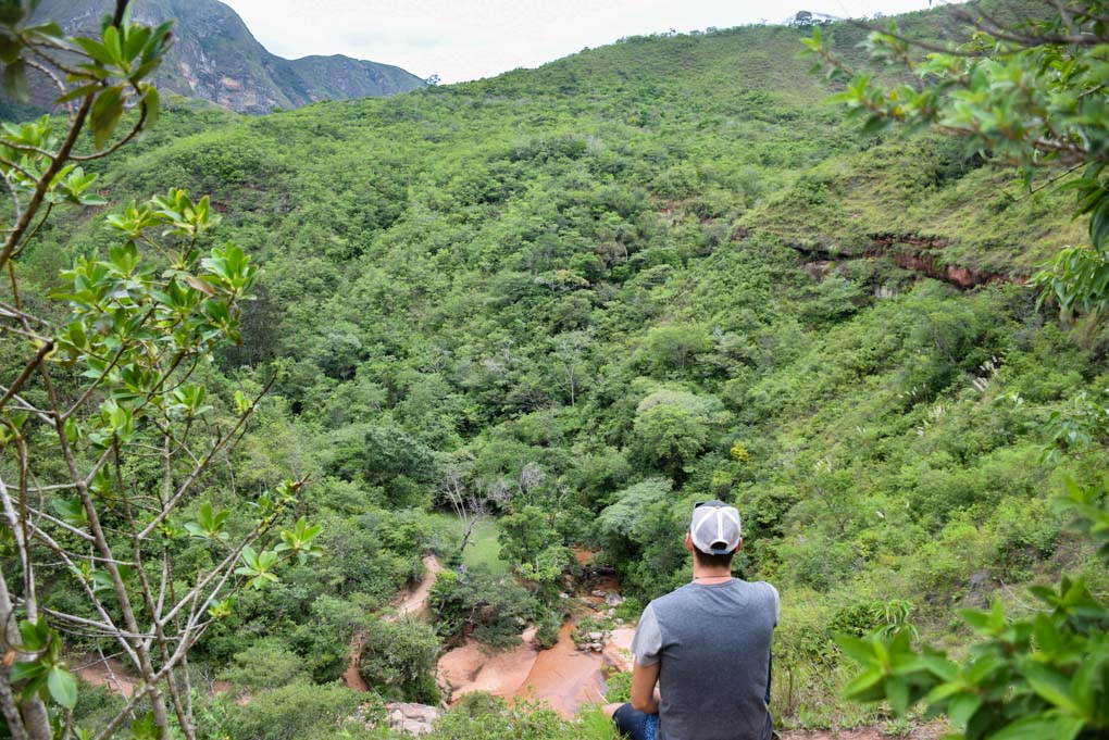 Daniel sits on a ledge overlooking the forest around Samaipata