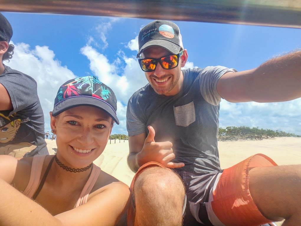 Bailey and Daniel sit on the back of a Dune buggy in Brazil
