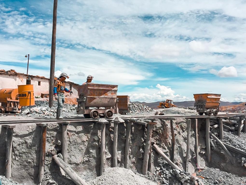 Workers push a cart on the outside of the Portosi Mines