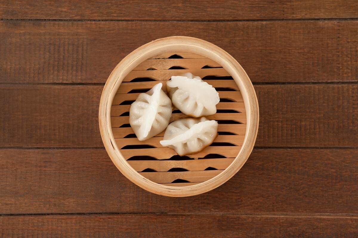 three teamed dumpings on a wooden container on a wooden table in a restaurants in Chinatown, Vancouver