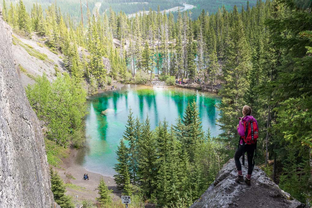 A lady stands on a rock overlooking the Grassi Lakes in Canmore, Canada