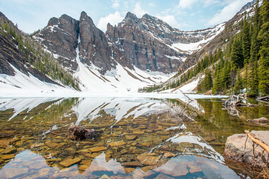 A panoramic photo of Lake Agnes with The Devils Thumb Mountain summit in the background
