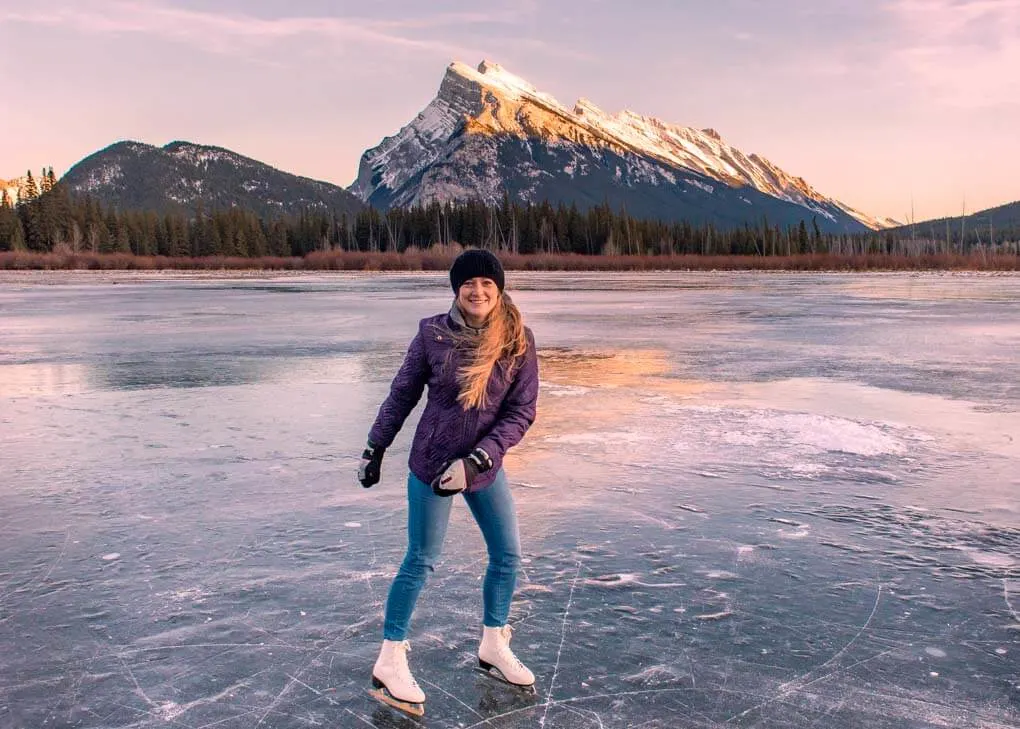 A lady ice skates on Vermilion Lakes, Banff