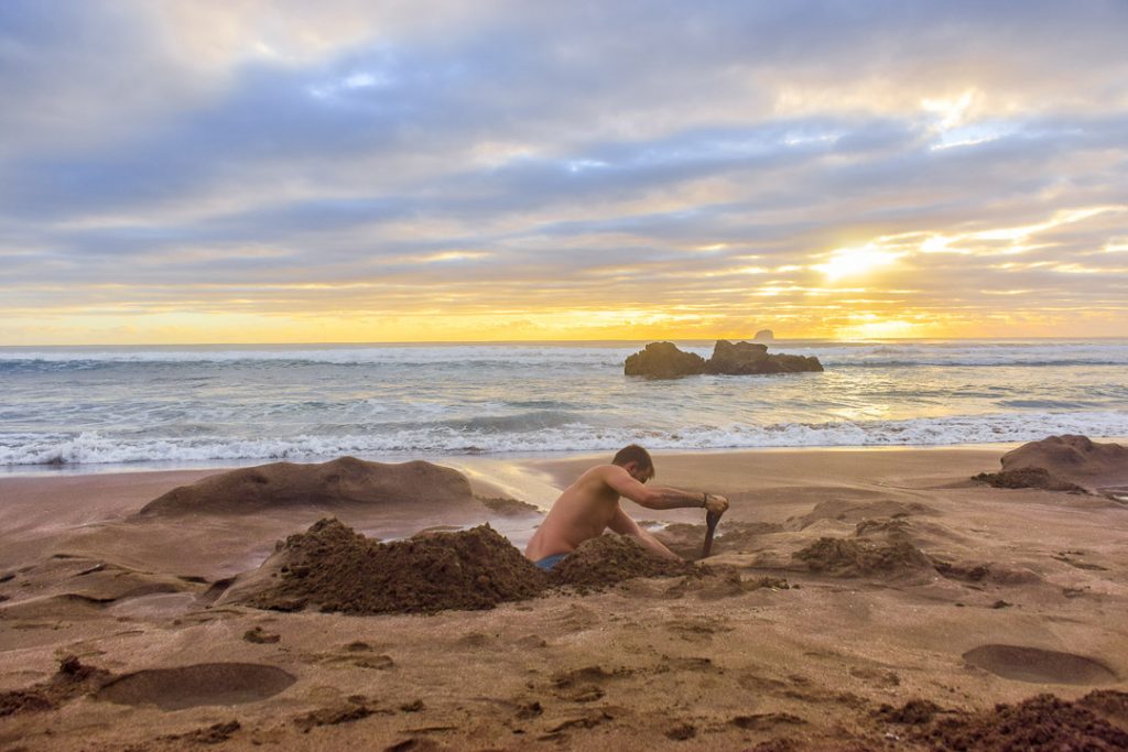 A man digging a hole at Hot Water Beach