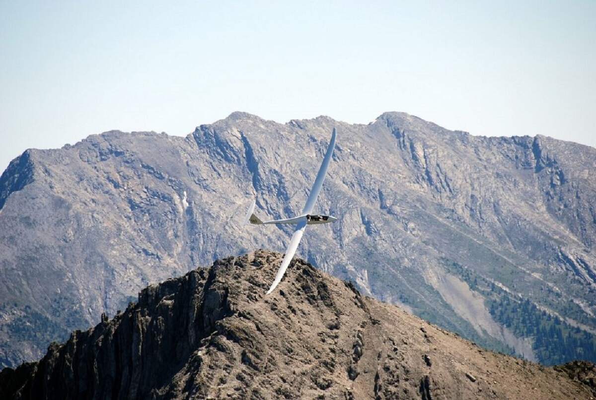 view of a plane soaring above the purcell mountains from the Invermere Soaring Centre