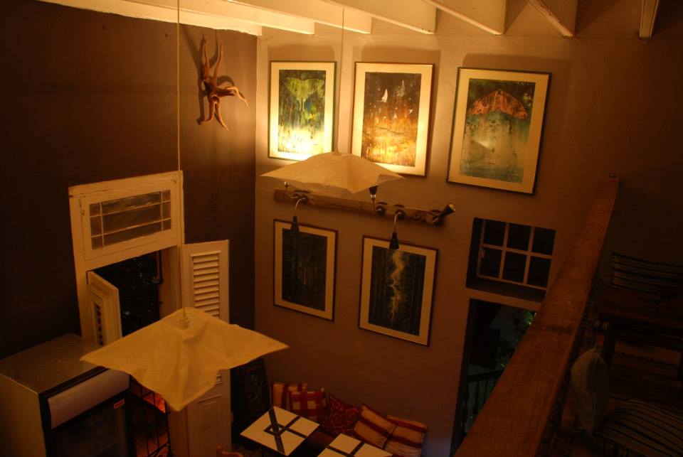the walls filled with art at Cafe Galeria Mamaine in Havana, Cuba
