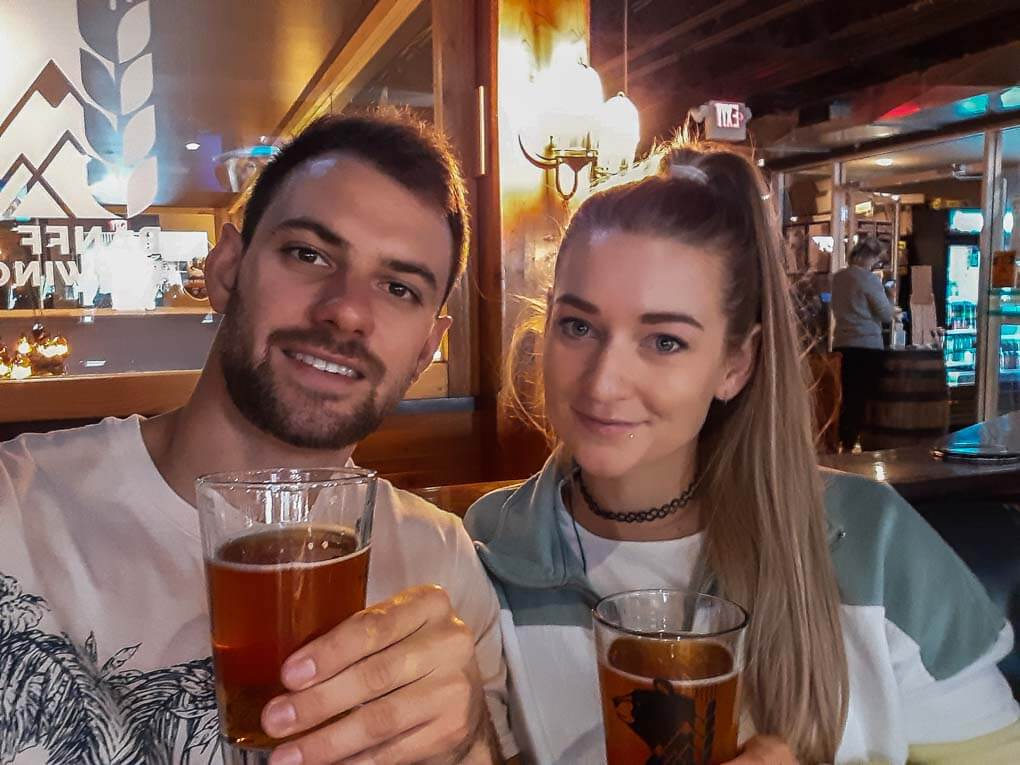 A couple take a selfie with beers at the Banff Brewery in Banff