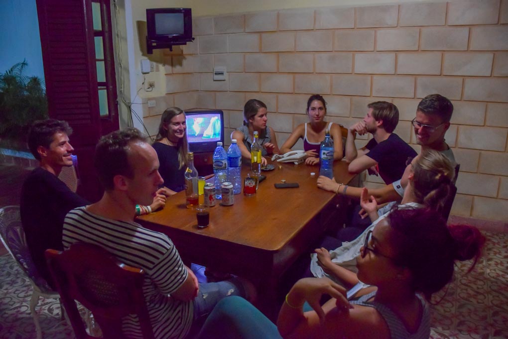 A groupd of people drink rum at a Casa Particular in Havana