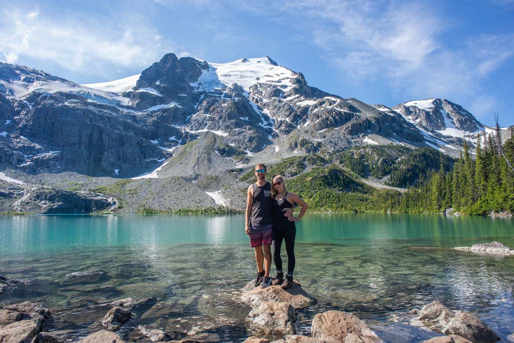 A couple stand on a rock at the Joffre Lakes near Whistler, BC