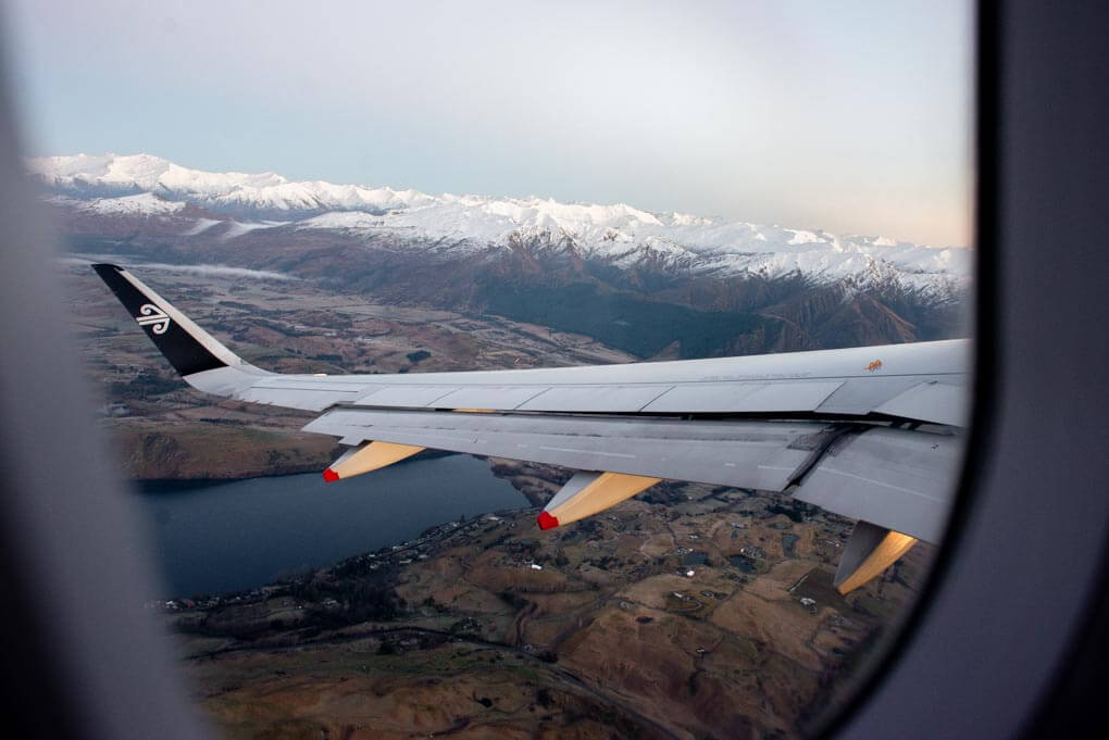 A plane flys over the mountains on a long haul international flight