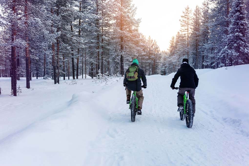 Tw people go fat biking through the snow