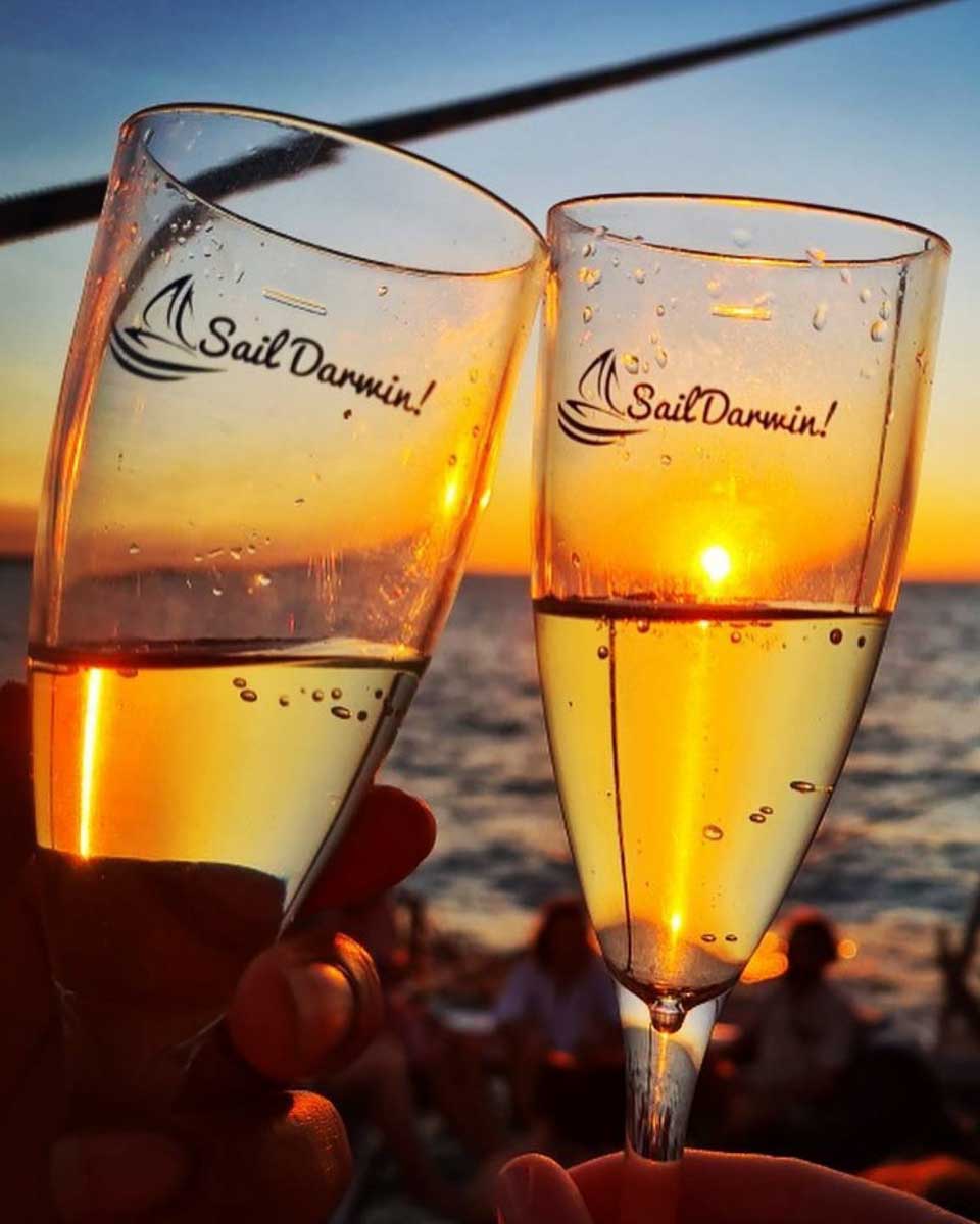 Two people cheers on a sunset cruise in Darwin