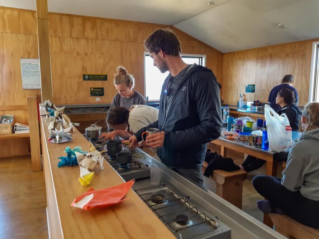 People cooking in the Luxmore Hut, New Zealand