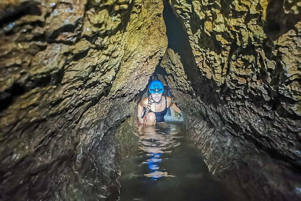 A lady crawls through the Venado Caves in La Fortuna