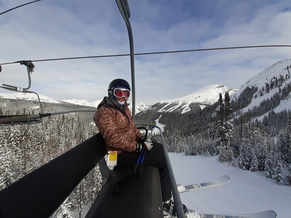 woman sitting on a chairlift at a ski resort in the Canadian Rockies