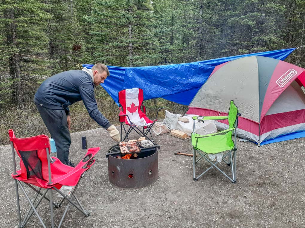 man cooking on the fire at a campsite