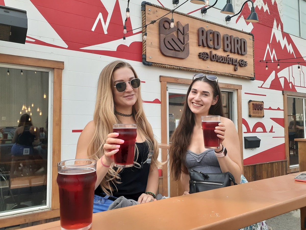 two women enjoying beers at the outdoor patio at Red Bird Brewing in Kelowna, BC