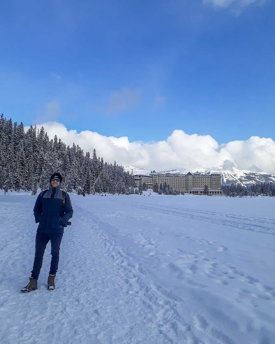 Daniel on Lake Louise in the winter with the Fairmont behind him
