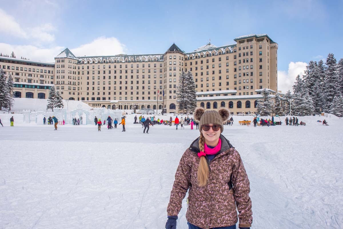 A lady stands in front fo the Fairmont Chateau Lake Louise