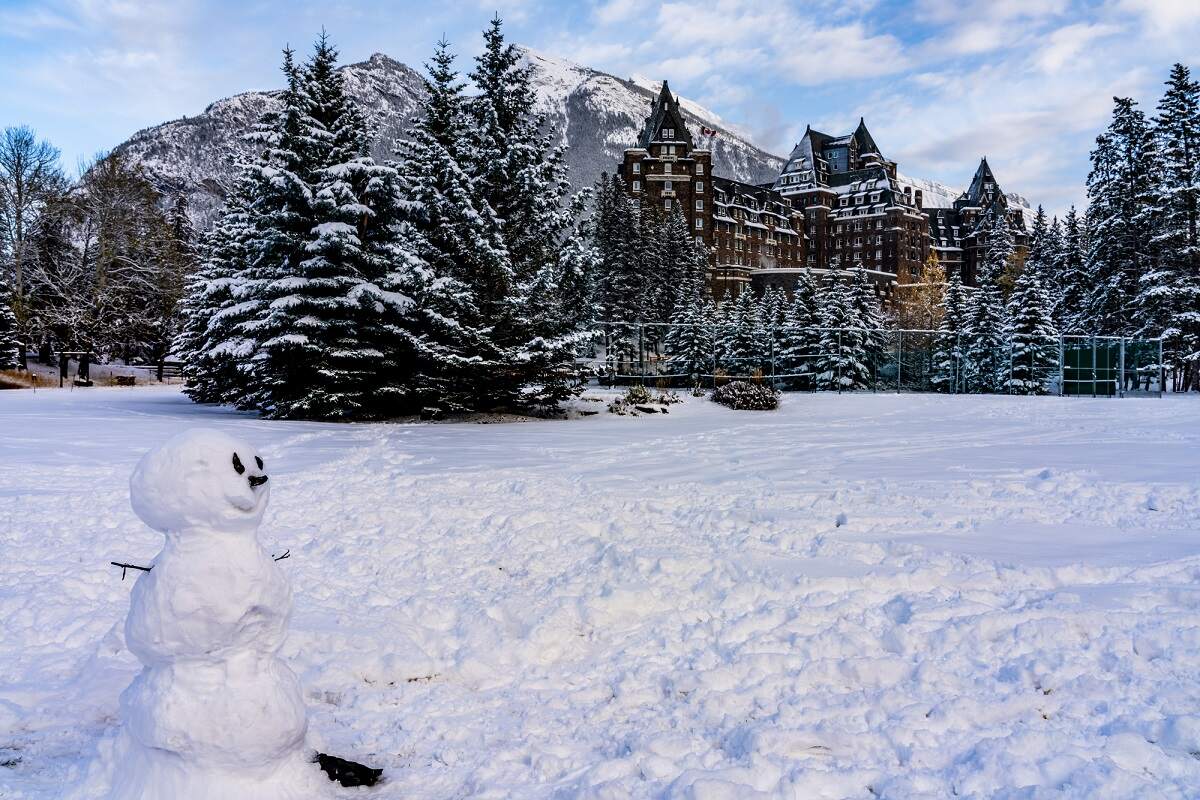 the Fairmont Banff Springs Hotel in the snow with a snowman infront