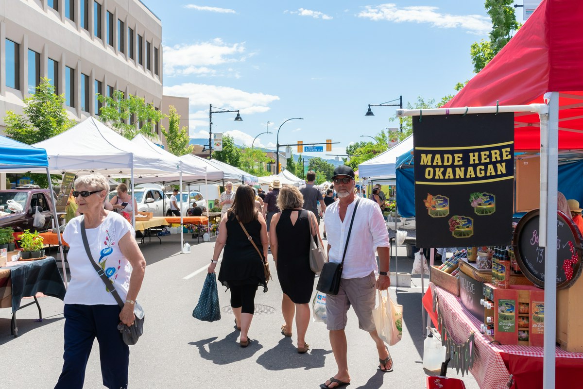 Locals and visitors exploring the Penticton Farmers' Market on a sunny day