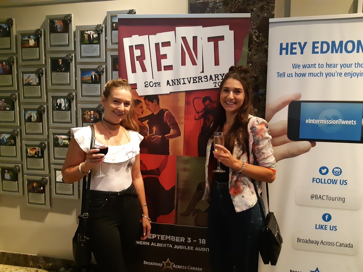 two woman standing by a Broadway Across Canada sign at the Jubilee Auditorium in Edmonton