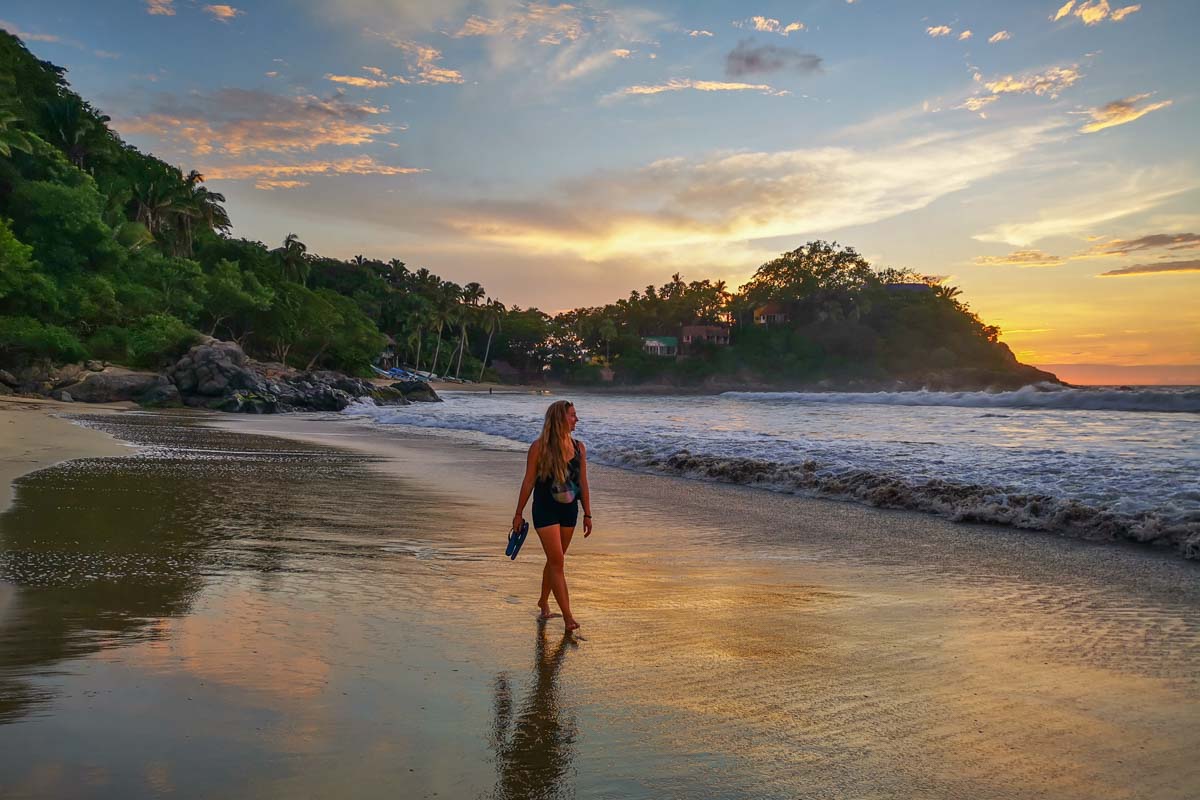 lady walks San Pancho Beach at sunset in Mexico