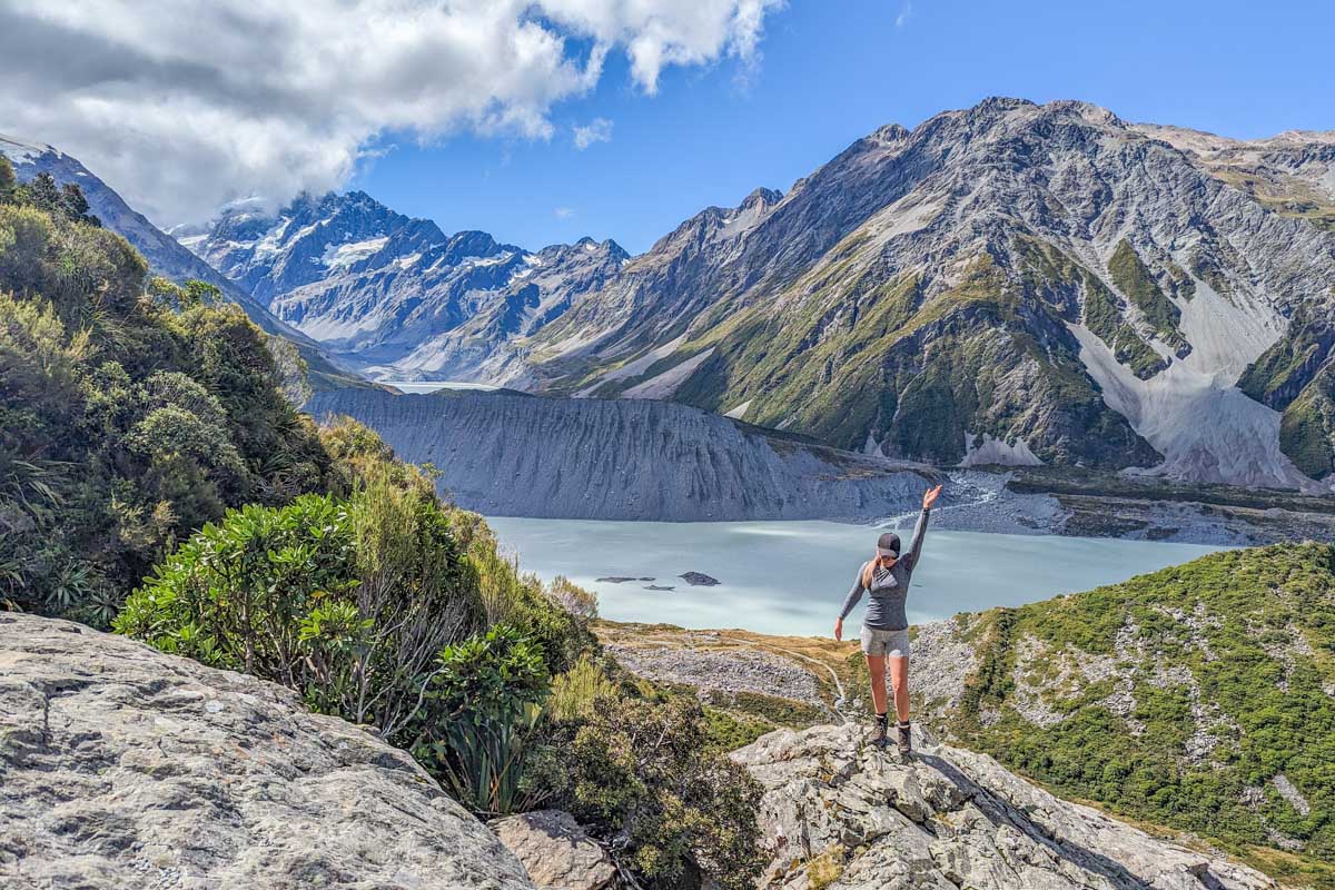 A lady hikes up the Sealy Tarns Track towards the Mueller Hut with views of Mount Cook