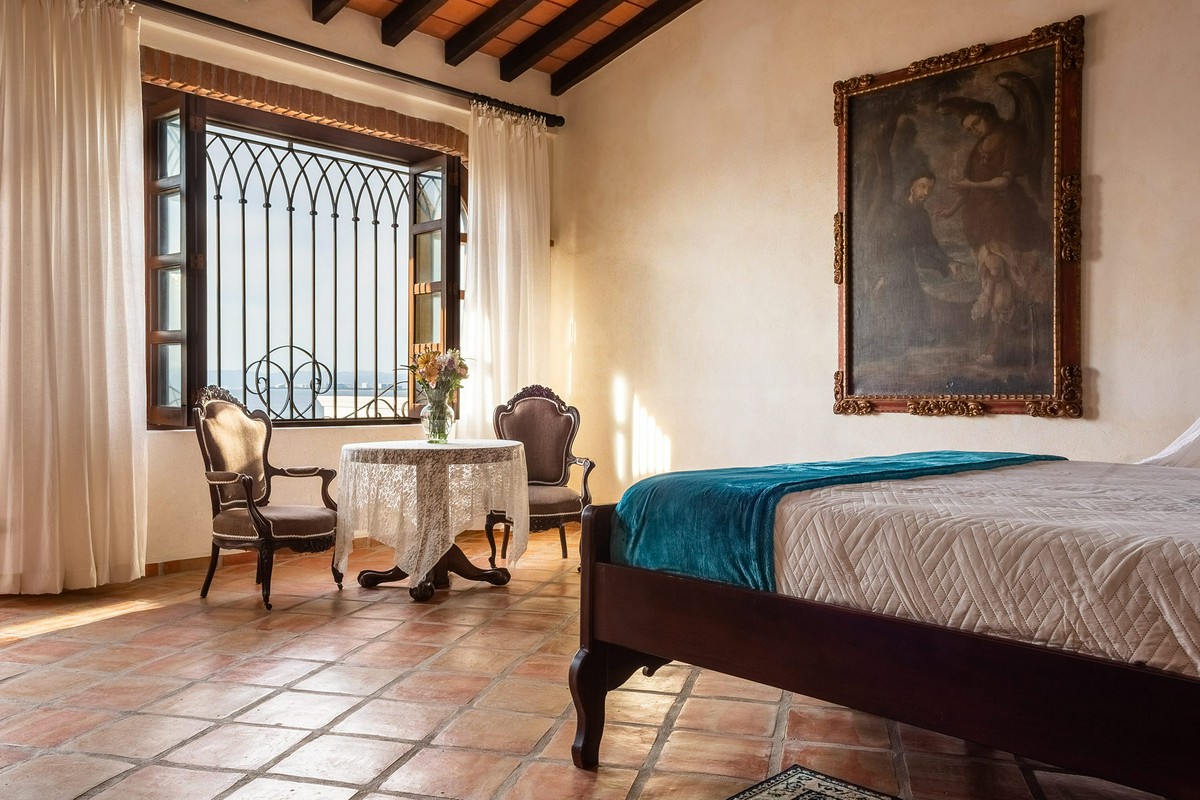 Bellview Hotel Boutique king suite with small table and chairs by the window.