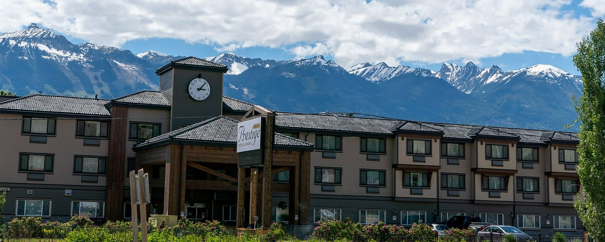 Prestige Inn Golden with snowcapped mountains in the back